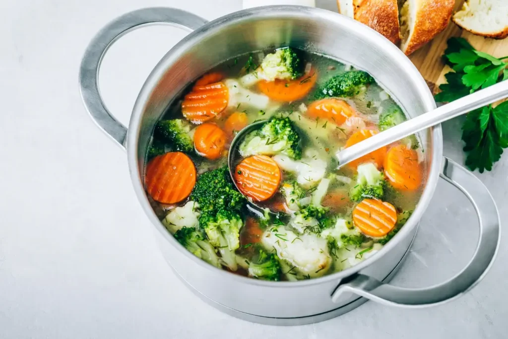 What Gives Vegetable Soup That Depth of Flavor? Expert Tips 8 A pot of simmering vegetable soup with a wooden spoon