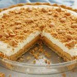 A close-up slice of Amish Peanut Butter Cream Pie shows creamy Peanut Butter Pie layers with fluffy Peanut Butter Cream Pie filling on a Graham Cracker Crust, topped with crumbs and peanuts like Amish Peanut Butter Pie.