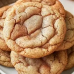 Stack of soft and chewy Apple Snickerdoodles on a plate, cinnamon sugar coating, fresh apples in the background, perfect fall treats