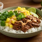 A green speckled bowl filled with white rice, tender shredded beef chuck roast, chipotle sauce drizzle, fresh pineapple chunks, cilantro, jalapeño slices, and lime wedges, showcasing Slow Cooker Recipes and Crockpot Chipotle Pineapple Pot Roast Bowls with a sweet and spicy bowl vibe.