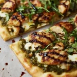 Pesto Chicken Flatbread 5 Pesto Chicken Flatbread with mozzarella, fresh arugula, and balsamic drizzle on a crispy crust, sliced on parchment for an easy weeknight dinner.