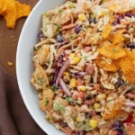 Cowboy Cabbage - Super VIRAL Recipe 5 Overhead bowl of Cowboy Cabbage with creamy coleslaw, black beans, corn, cheddar, and crunchy corn chips on a wooden table