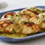 Grilled Salsa Verde Pepper Jack Chicken on a blue platter, juicy chicken breasts topped with creamy pepper jack and salsa verde, cilantro and lime wedges