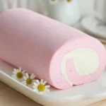 Japanese Cotton Candy Swiss Cake Roll 5 Pastel pink Japanese Cotton Candy Swiss Cake Roll with creamy white swirl on a platter
