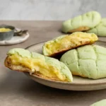 Japanese Honeydew Bread Recipe | Cloud-Soft Milk Bread, Foolproof Method 5 Fresh Japanese honeydew bread on a cooling rack, pale green milk bread with crosshatch tops, one bun sliced to show creamy filling, homemade recipe