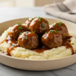 Salisbury Steak Meatballs with mushroom gravy served over creamy mashed potatoes, parsley garnish, cozy comfort food dinner idea