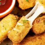 Golden air fryer mozzarella sticks with gooey cheese pull, crispy breadcrumb coating, served with marinara dipping sauce, easy appetizer recipe