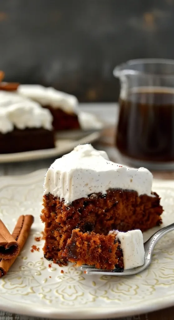 Moist Gingerbread Molasses Cake with thick spiced frosting, a forkful lifted from the slice, cozy holiday dessert beside a glass mug of coffee