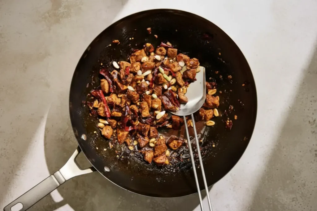 Wok of Kung Pao Chicken with peanuts, dried chilies, and glossy spicy sauce, a quick stir fry for an easy Chinese dinner
