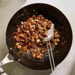Wok of Kung Pao Chicken with peanuts, dried chilies, and glossy spicy sauce, a quick stir fry for an easy Chinese dinner