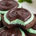 Baked Grasshopper Cake Mix Cookies topped with chocolate and mint frosting