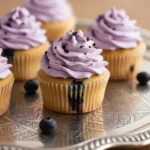 Delicious blueberry cupcakes with frosting on a white plate