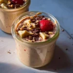 A creamy bowl of blended overnight oats topped with fruits and nuts